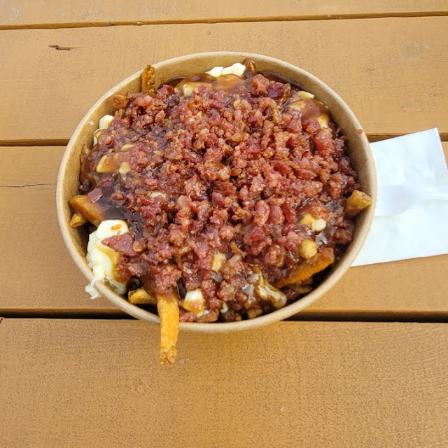 Bacon-loaded poutine in a bowl