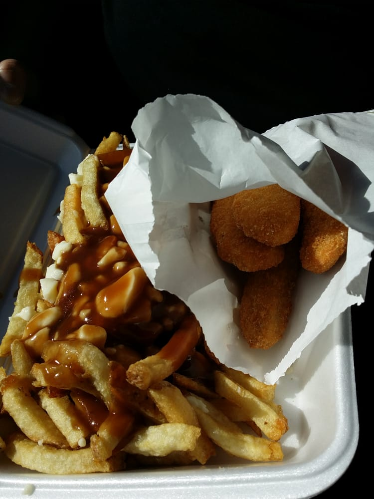 Fries with gravy and cheese curds beside breaded nuggets